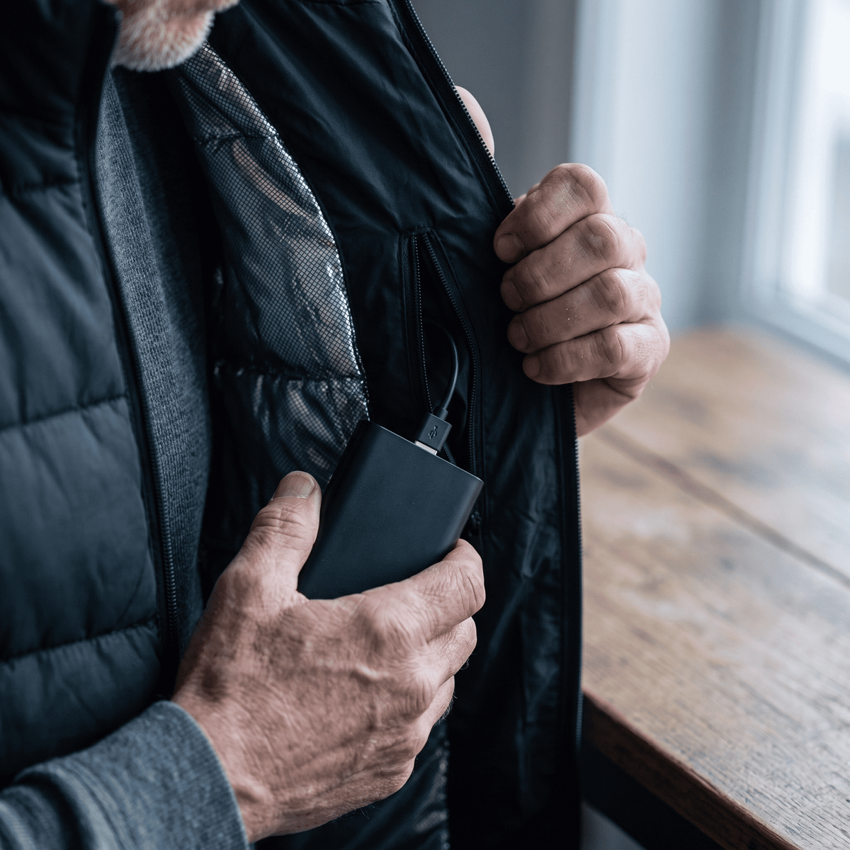 Power bank being slipped into the inside pocket of the heated vest